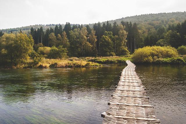 Bridge over water with trees in the distance.